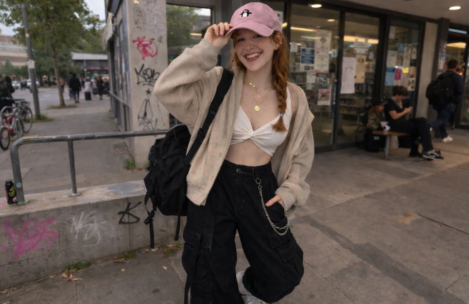 jeune femme avec casquette coréenne rose brodée style streetwear K-fashion pantalon cargo noir