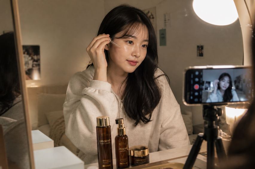 Jeune femme coréenne filmant sa routine skincare au ginseng dans une ambiance K-beauty chaleureuse