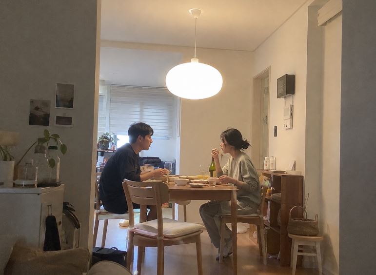 Couple prenant un repas sous une suspension ronde dans un appartement coréen
