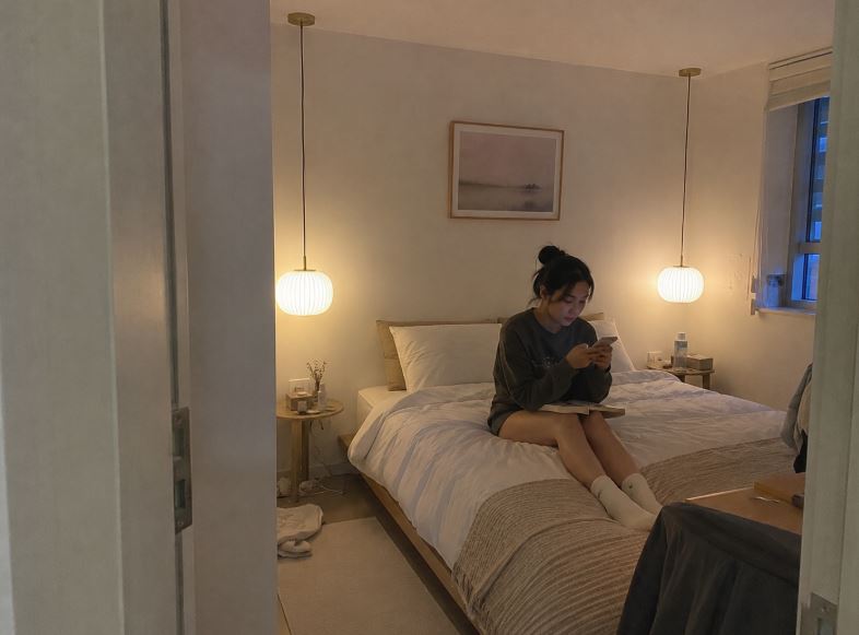 Deux suspensions en verre opalin installées de chaque côté d’un lit bas